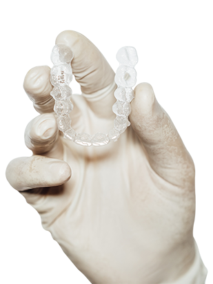 dentist-holding-clear-dental-aligner.png
