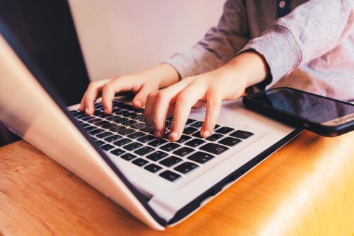 mains-d-enfant-sur-le-clavier-ordinateur-portable-a-cote-un-telephone-pour-faire-des-affaires-168556923.jpg