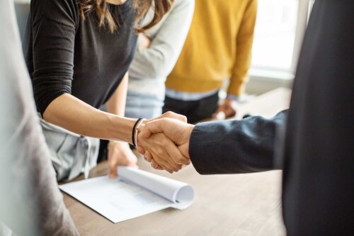 Business-people-shaking-hands-in-office-stock-photo-min-1.jpg