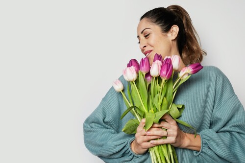smiling-young-girl-holding-colored-tulips-bouquet-isolated-over-gray-background.jpg