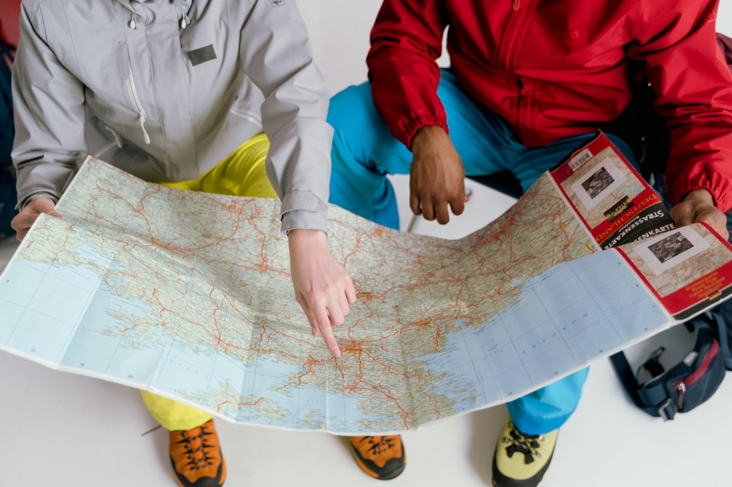 Two people looking through a large map.