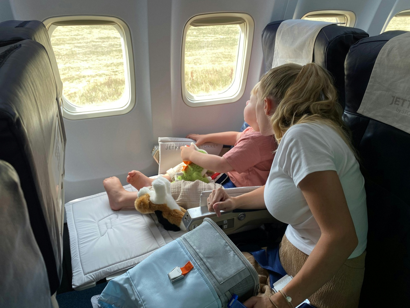 A mother and son sitting in an airplane. 