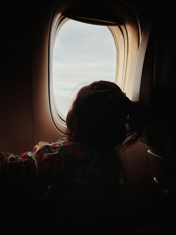 A child looking out the plane window 