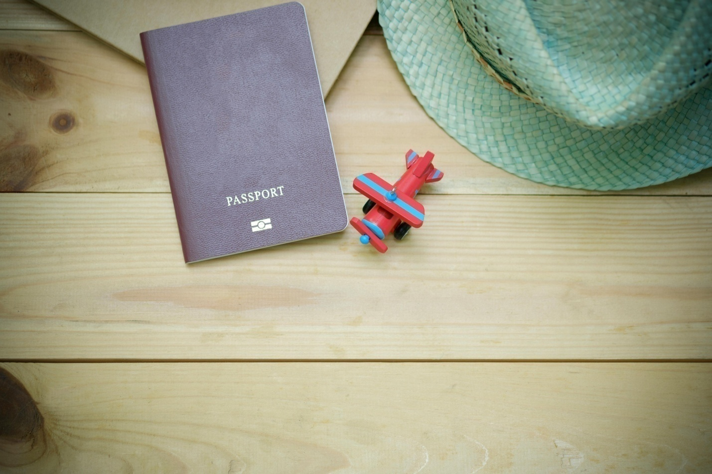 A Passport next to a tiny rubber plane.