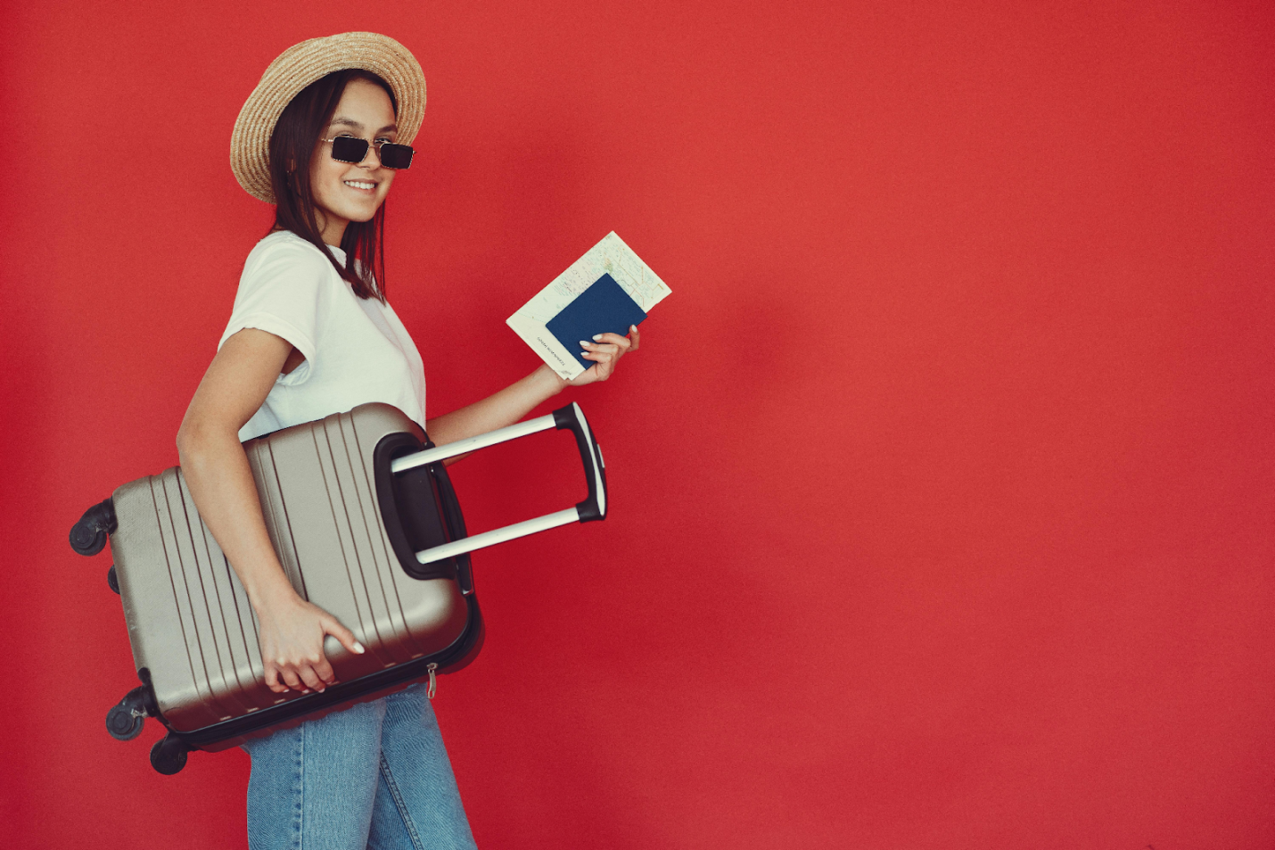 A woman holding a suitcase and passport 