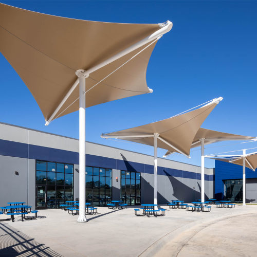 A-large-building-featuring-multiple-expansive-shade-sails-providing-ample-coverage-and-protection-from-the-sun.png